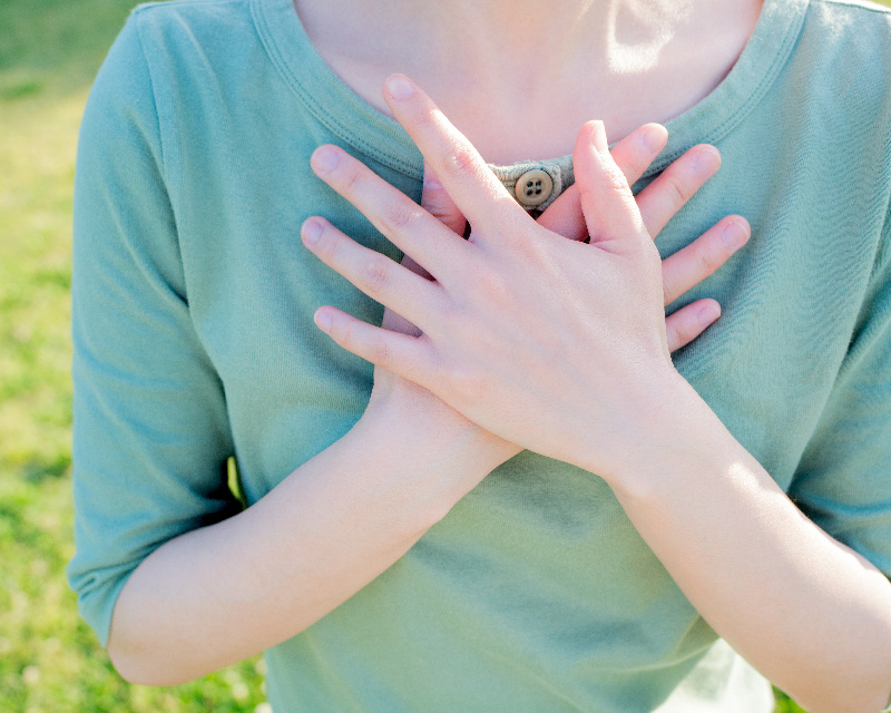 Woman with hands on heart trying to regulate anxiety