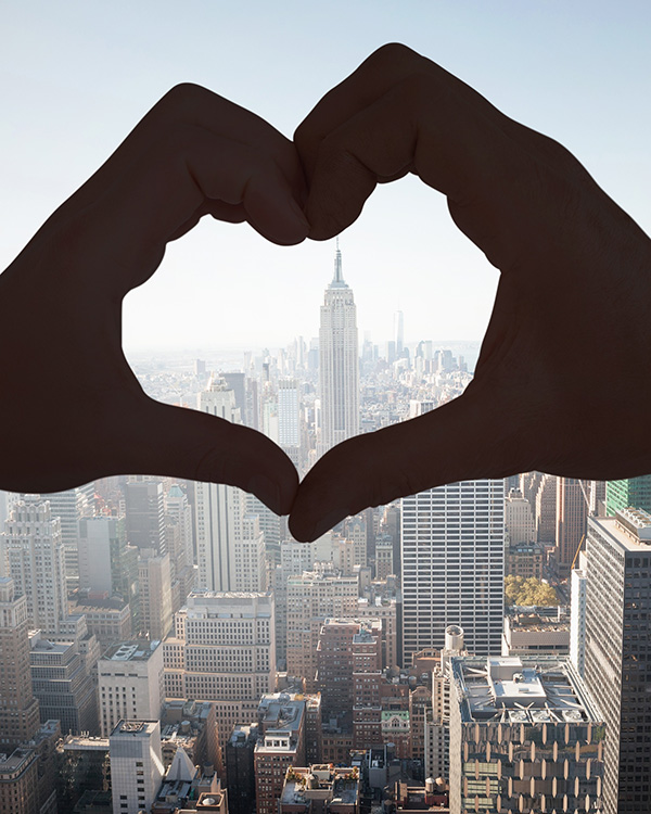 Heart with hands over New York City skyline