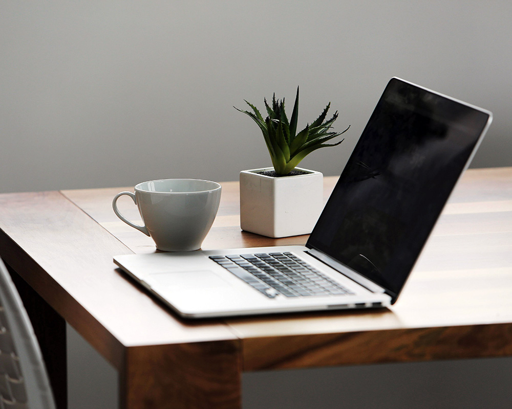 laptop on a table with coffee cup